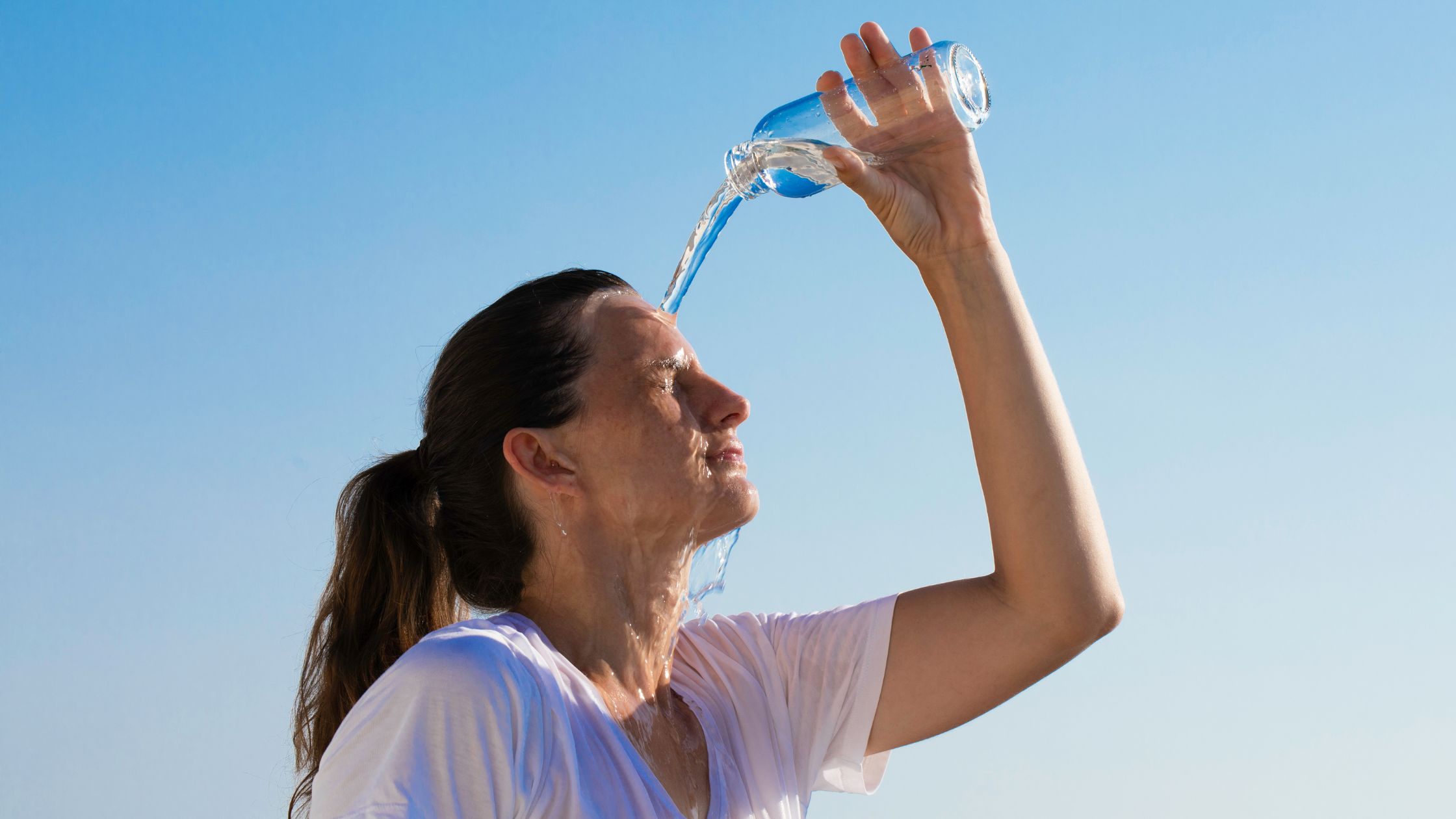 Femme se rafraîchissant avec de l’eau pendant une période de forte chaleur