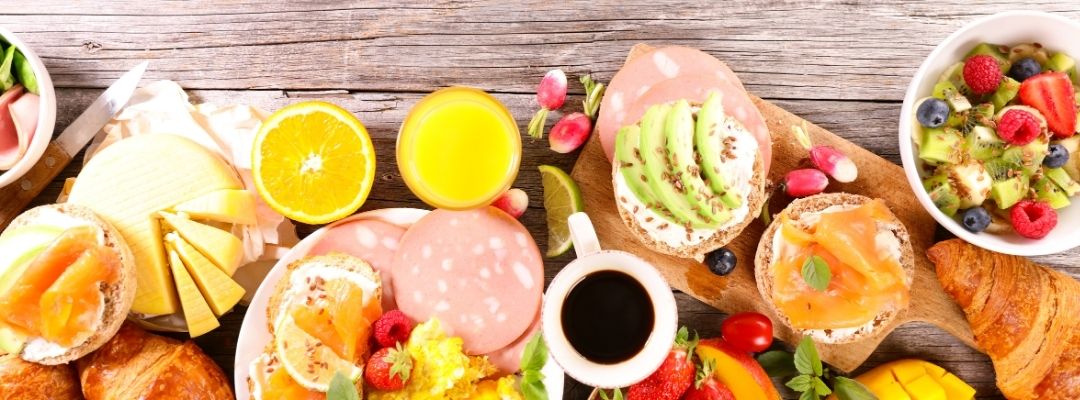 Repas varié avec fruits, pain, œufs, saumon et avocat pendant une période de forte chaleur