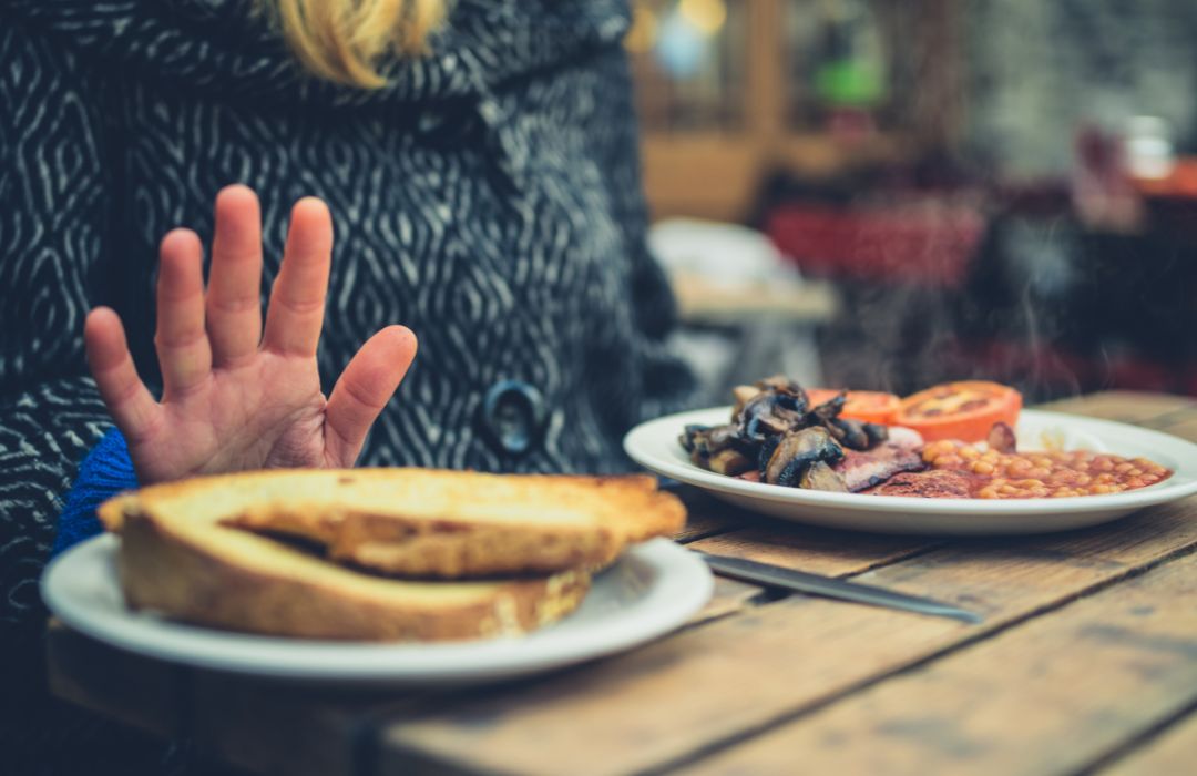 Alimentation, ballonnements et ventre gonflé à la ménopause Femme refusant un repas susceptible d’accentuer les ballonnements et le ventre gonflé à la ménopause