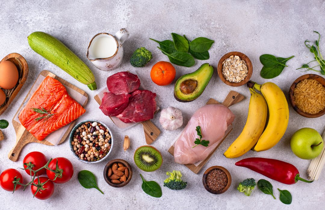Nutrition équilibrée et performance durable Aliments variés riches en protéines, bons lipides, fruits et légumes, illustrant la nutrition au service de l’énergie, de la récupération et de la performance durable